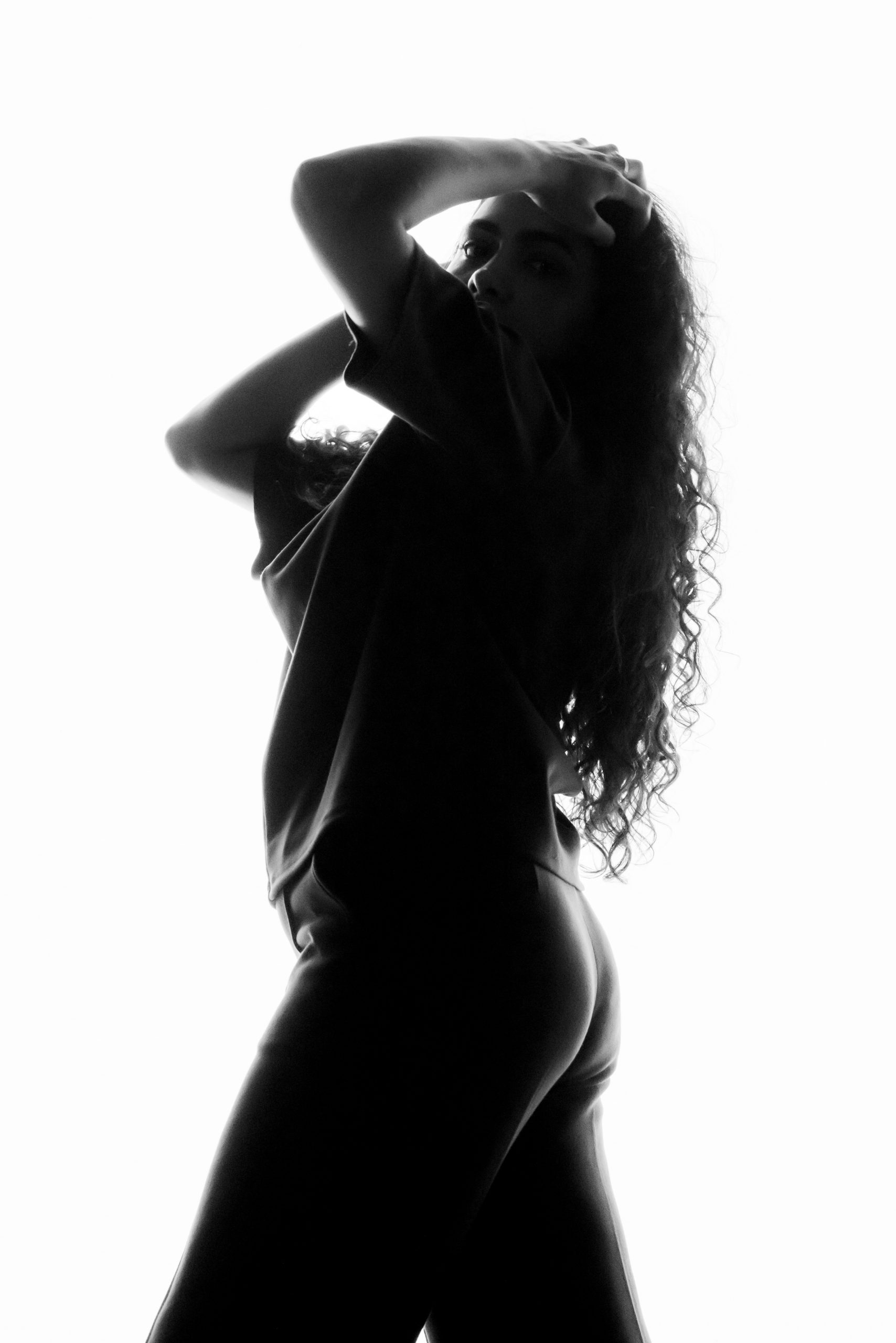 Black and white silhouette of a woman against a bright sky
