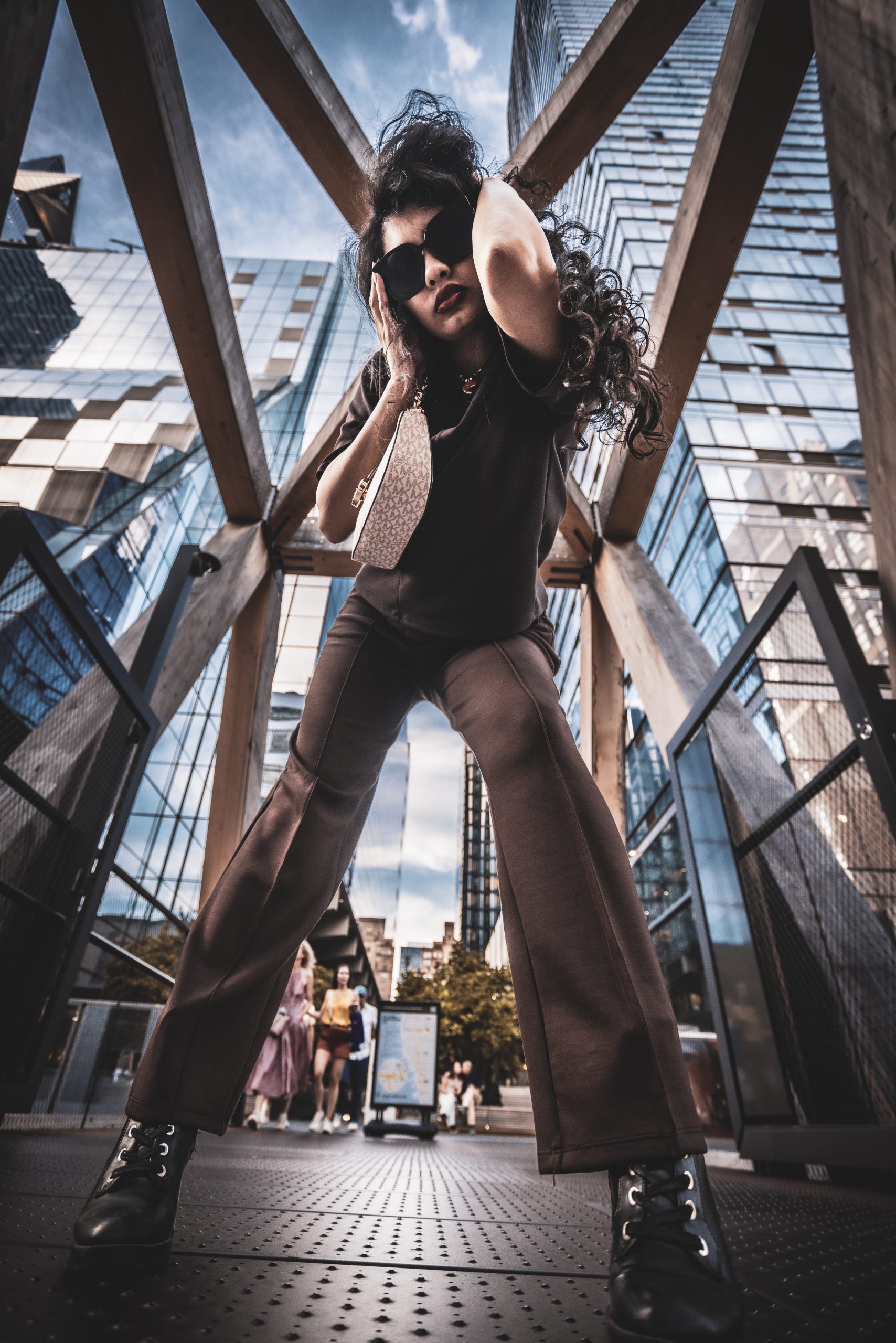 Woman standing beneath large architectural beams, low angle, urban setting