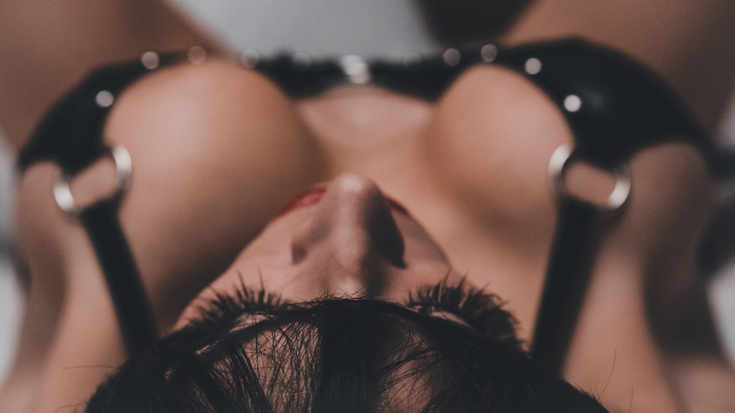 Close, intimate portrait in dark lingerie with dramatic low lighting
