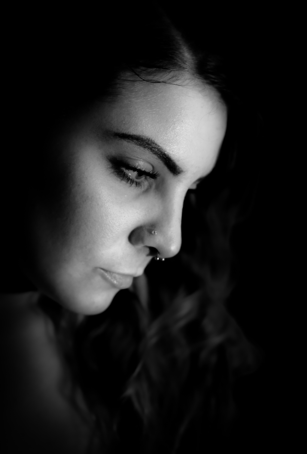 Black and white profile portrait of a woman with a nose ring, soft directional light
