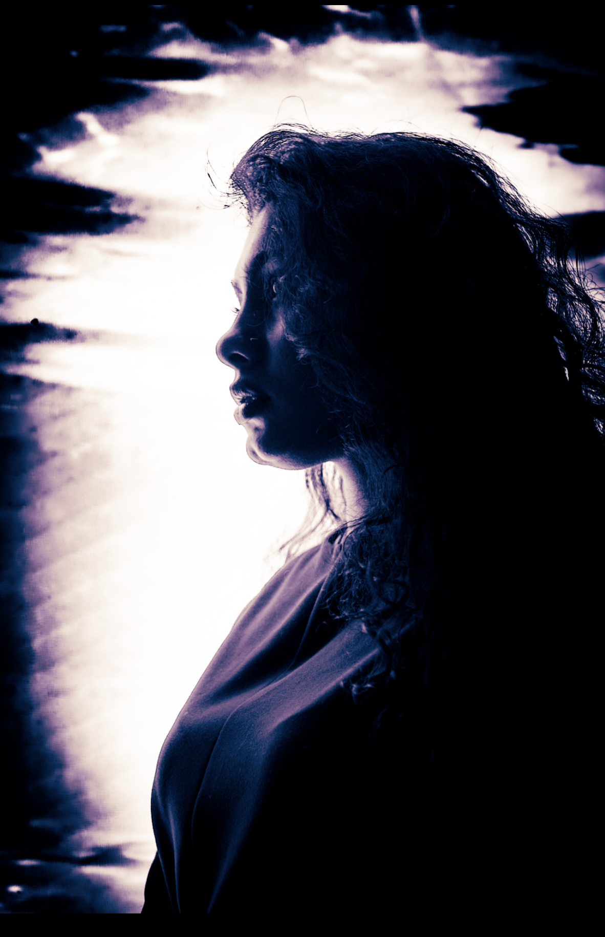 Purple-toned silhouette of a woman in profile against a bright, cloud-streaked sky