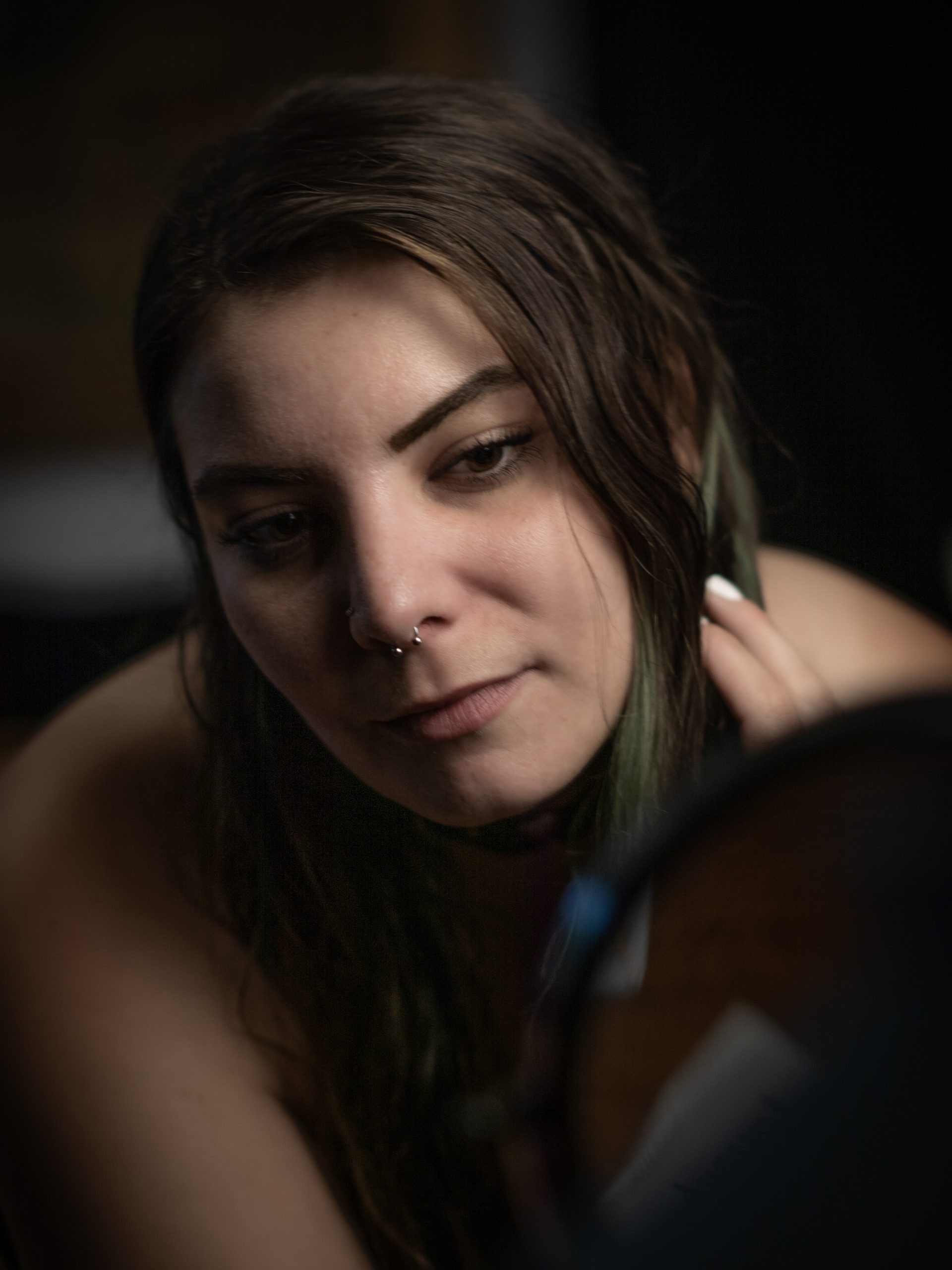 Woman touching her hair near a mirror, soft intimate lighting